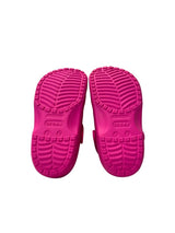 Pink children's shoes with textured soles on a white background