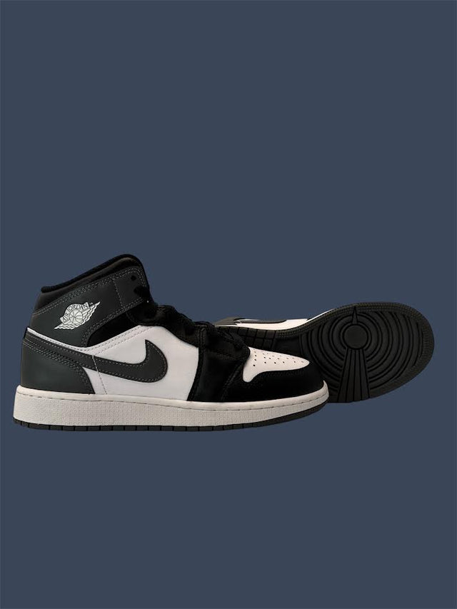 Black and white high-top sneaker on a dark blue background