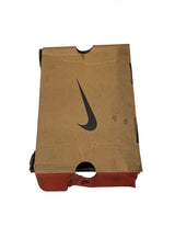 Brown paper bag with a black Nike logo on a white background