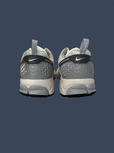 Gray and white Nike sneakers on a dark blue background