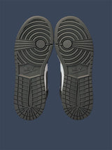 Close-up of a pair of Nike shoes with tread pattern on a dark blue background