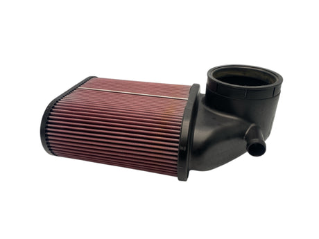 Car air filter with black outer shell and red pleated media on a white background