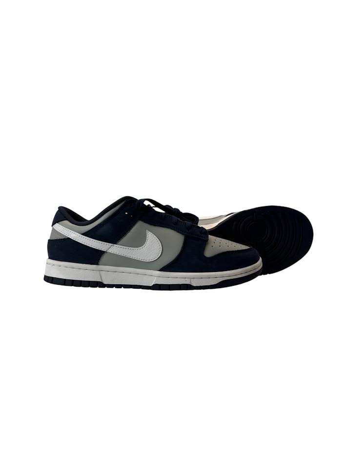 Navy blue and gray sneaker with a visible brand logo on a white background