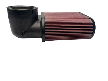 Black air filter housing with a red pleated filter on a white background